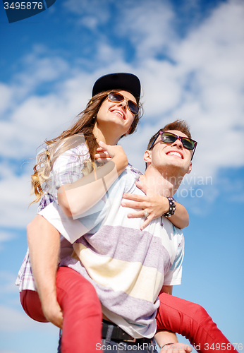 Image of smiling teenagers in sunglasses having fun outside