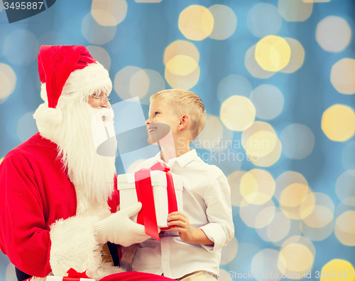 Image of smiling little boy with santa claus and gifts