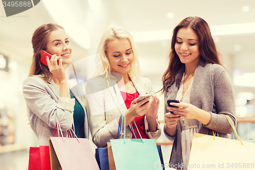 Image of happy women with smartphones and shopping bags