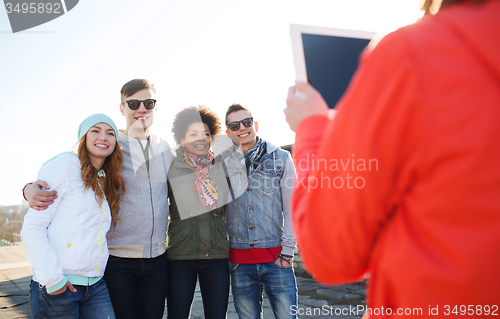 Image of happy teenage friends with tablet pc photographing