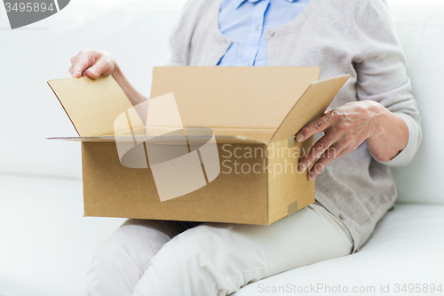 Image of close up of senior woman with parcel box at home