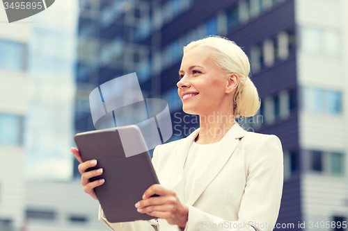 Image of smiling businesswoman with tablet pc outdoors