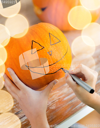Image of close up of woman with pumpkins at home