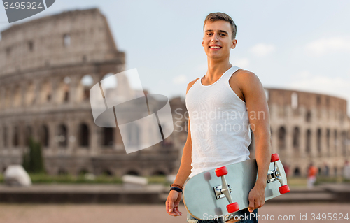 Image of smiling teenage boy with skateboard over coliseum