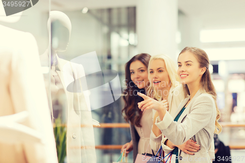 Image of happy young women with shopping bags in mall