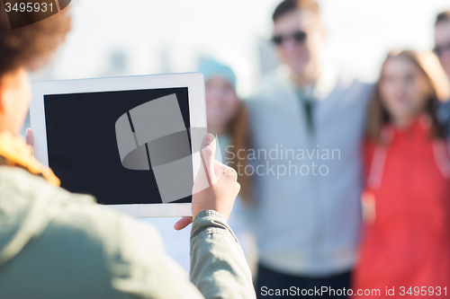 Image of close up of friends with tablet pc photographing