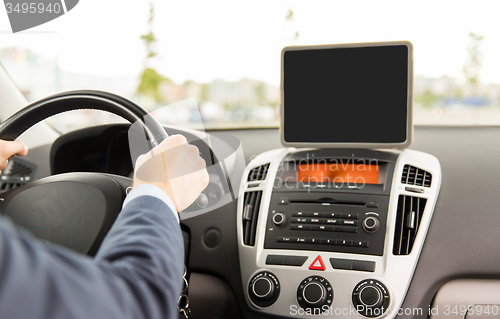 Image of close up of young man with tablet pc driving car