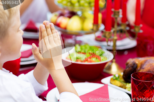 Image of close up of boy praying at christmas dinner