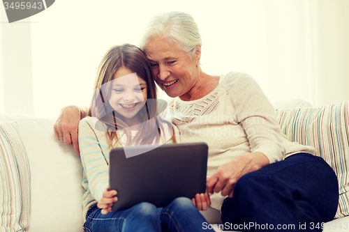 Image of smiling family with tablet pc at home