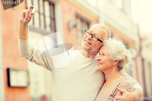 Image of senior couple photographing on city street