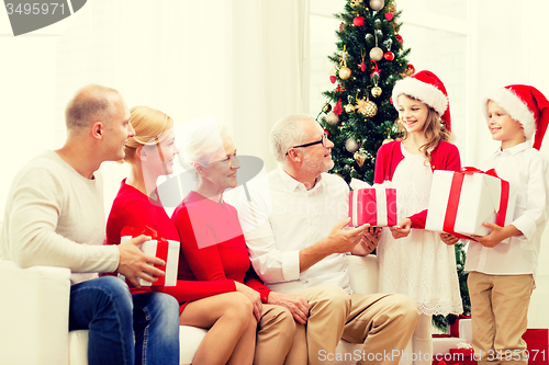 Image of smiling family with gifts at home