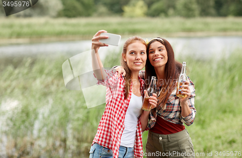 Image of happy women taking selfie by smartphone outdoors