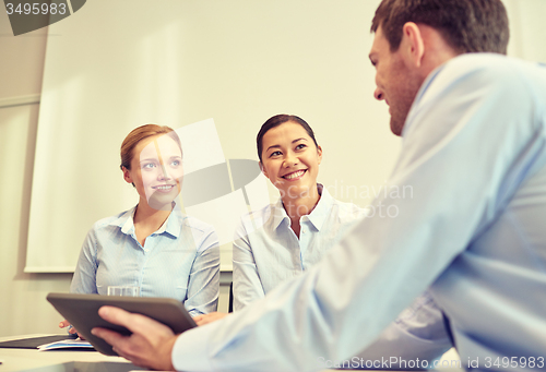 Image of smiling businesspeople with tablet pc in office