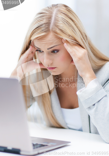 Image of stressed woman with laptop