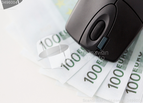 Image of close up of computer mouse and euro cash money