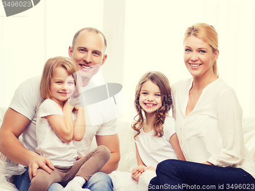 Image of smiling parents and two little girls at new home