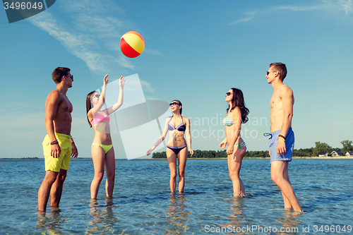 Image of smiling friends in sunglasses on summer beach