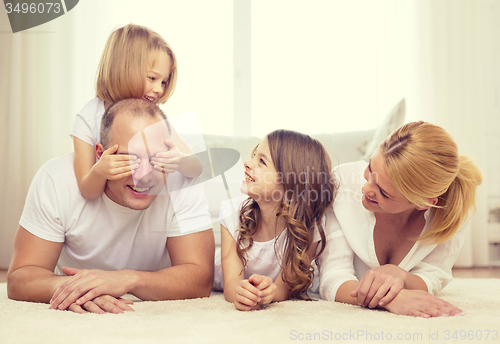 Image of parents and two girls lying on floor at home