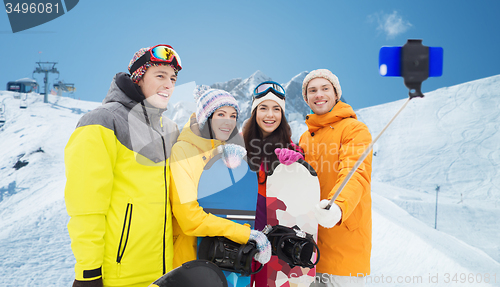 Image of happy friends with snowboards and smartphone