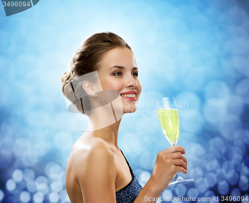 Image of smiling woman holding glass of sparkling wine