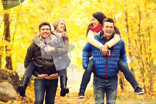 Image of smiling friends having fun in autumn park