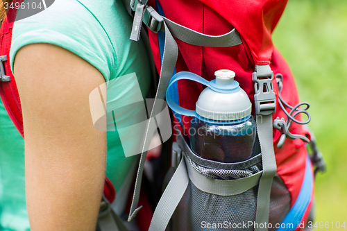 Image of close up of woman with water bottle in backpack