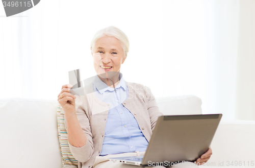 Image of senior woman with laptop and credit card at home