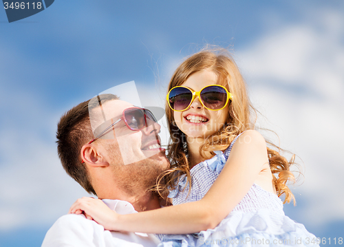 Image of happy father and child in sunglasses over blue sky