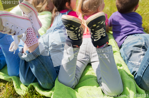 Image of close up of kids lying on picnic blanket outdoors