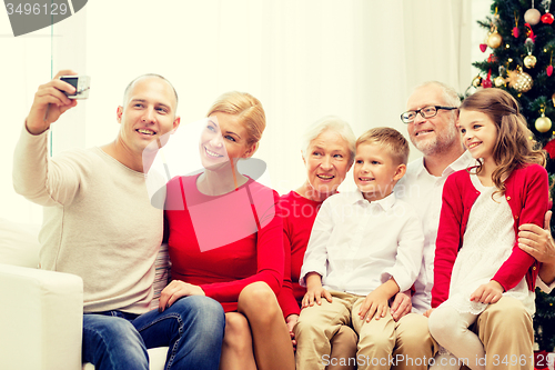 Image of smiling family with camera at home