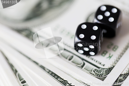 Image of close up of black dice and dollar cash money