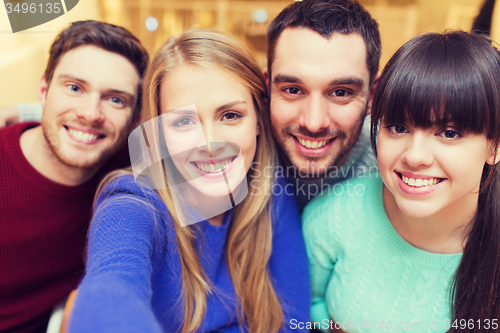 Image of group of smiling friends taking selfie
