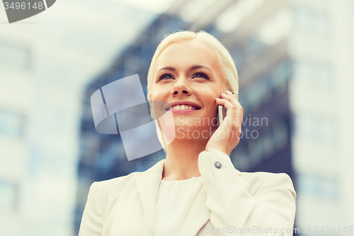 Image of smiling businesswoman with smartphone outdoors