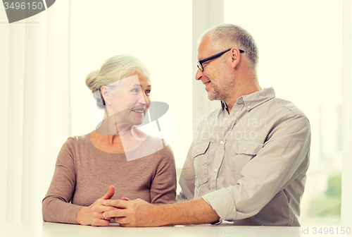 Image of happy senior couple sitting on sofa at home