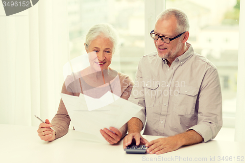 Image of senior couple with papers and calculator at home