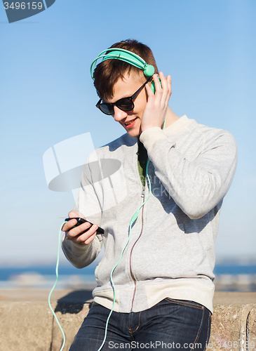 Image of happy young man in headphones with smartphone