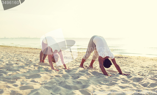 Image of couple making yoga exercises outdoors