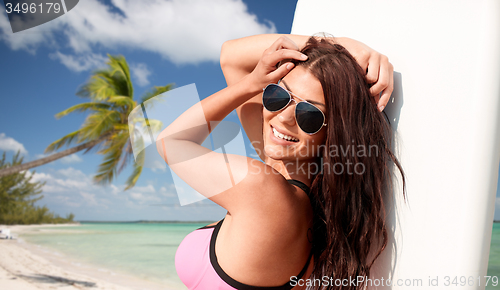Image of smiling young woman with surfboard on beach
