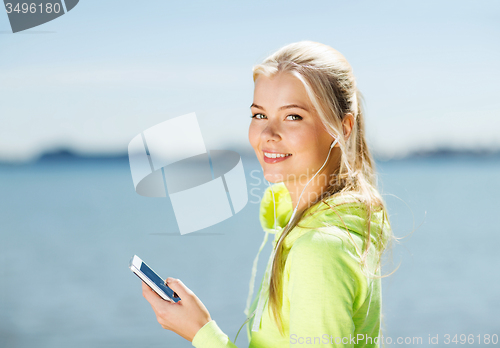 Image of woman listening to music outdoors