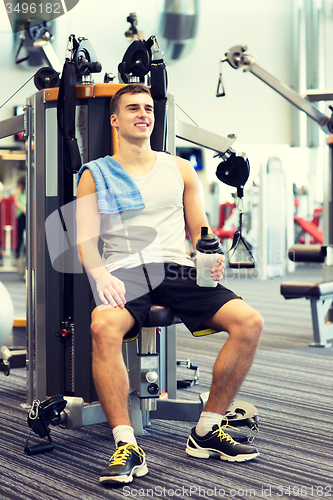 Image of smiling man exercising on gym machine