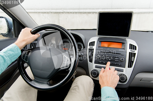 Image of close up of young man with tablet pc driving car