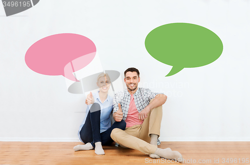 Image of happy couple showing thumbs up at new home