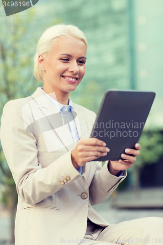 Image of smiling businesswoman with tablet pc outdoors