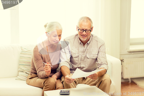 Image of senior couple with papers and calculator at home