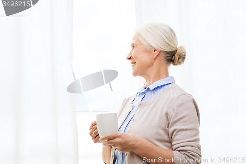 Image of happy senior woman with cup of tea or coffee
