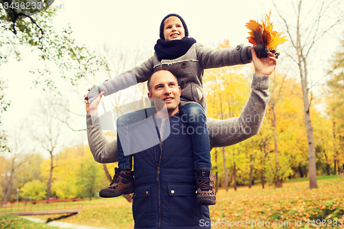 Image of happy family having fun in autumn park