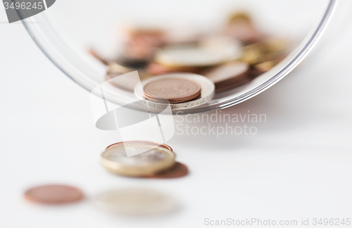 Image of close up of euro coins in glass jar on table