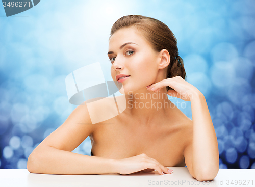 Image of beautiful young woman touching her face and neck