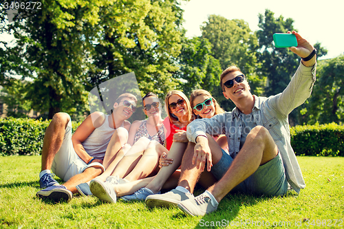 Image of smiling friends with smartphone making selfie