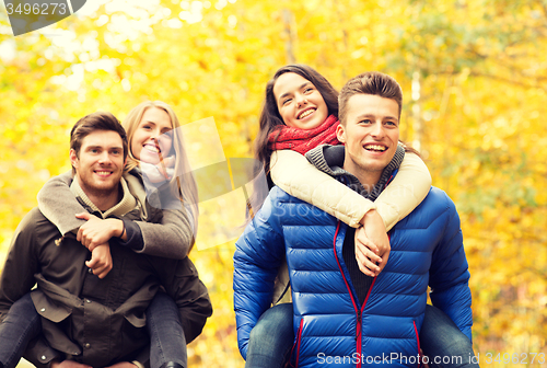 Image of smiling friends having fun in autumn park